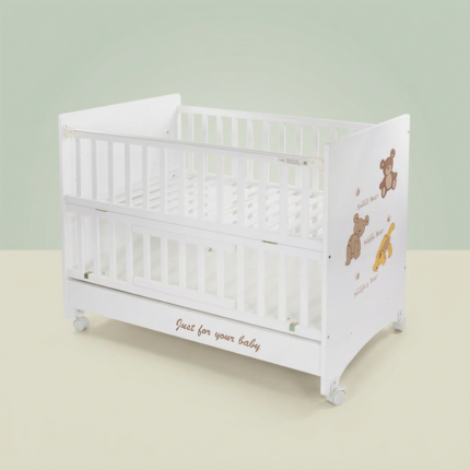 White wooden baby cot photographed against an elegant pale sage green studio background